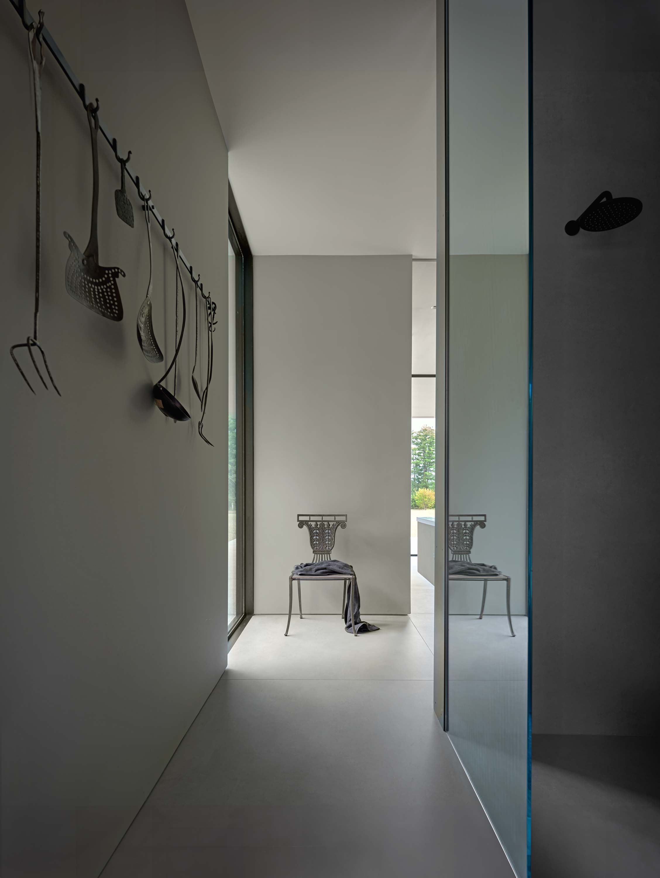 Interior photo of the Casa Annunziata Residence by Specht Novak Architects. Shot by Dror Baldinger, featuring an intimate hallway with a shower to the right and a bedroom entrance at its end.