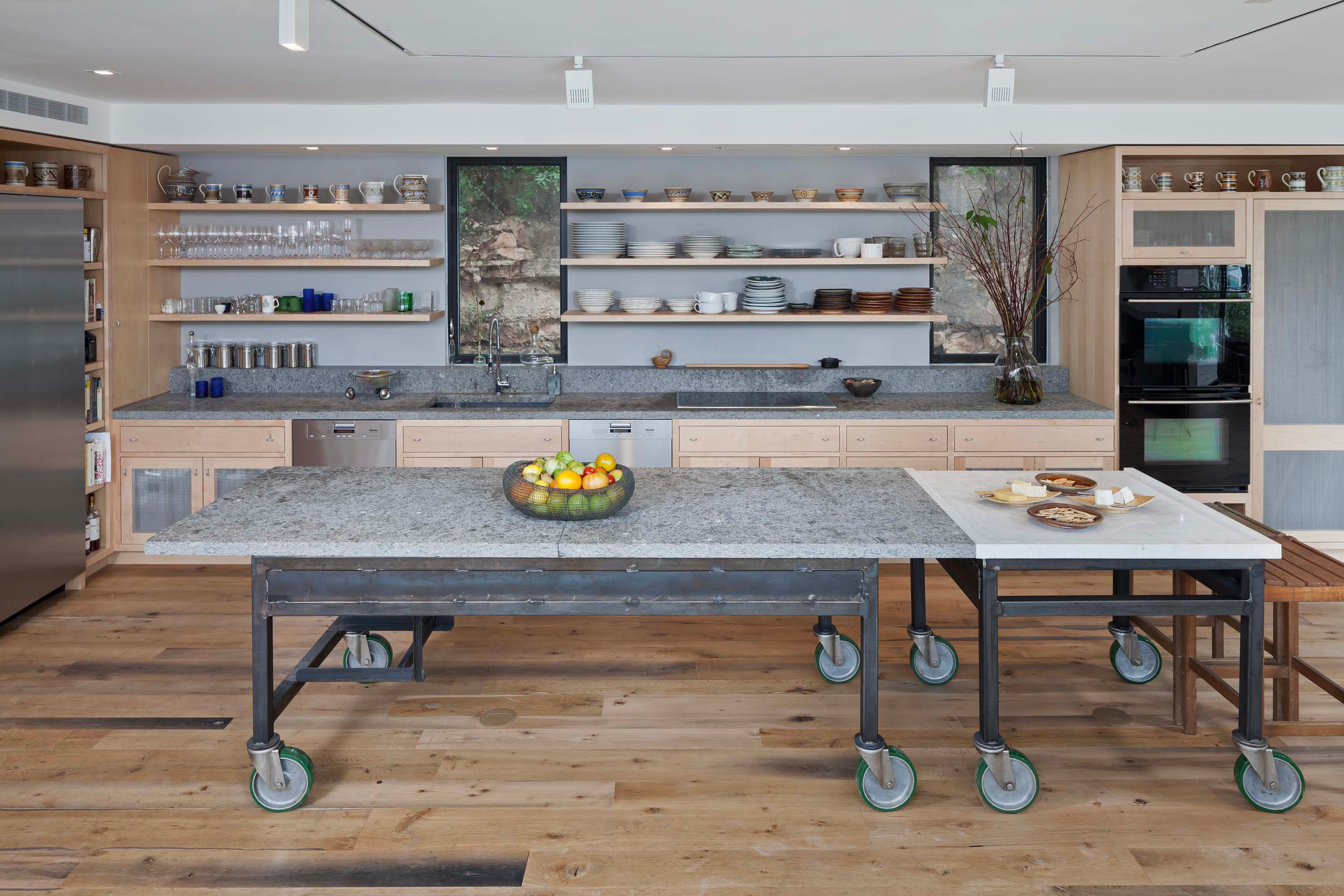 Interior photo of the Cliffside Residence by Specht Novak Architects. Shot by Andrea Calo, featuring the kitchen, wooden floors, and industrial Island table.