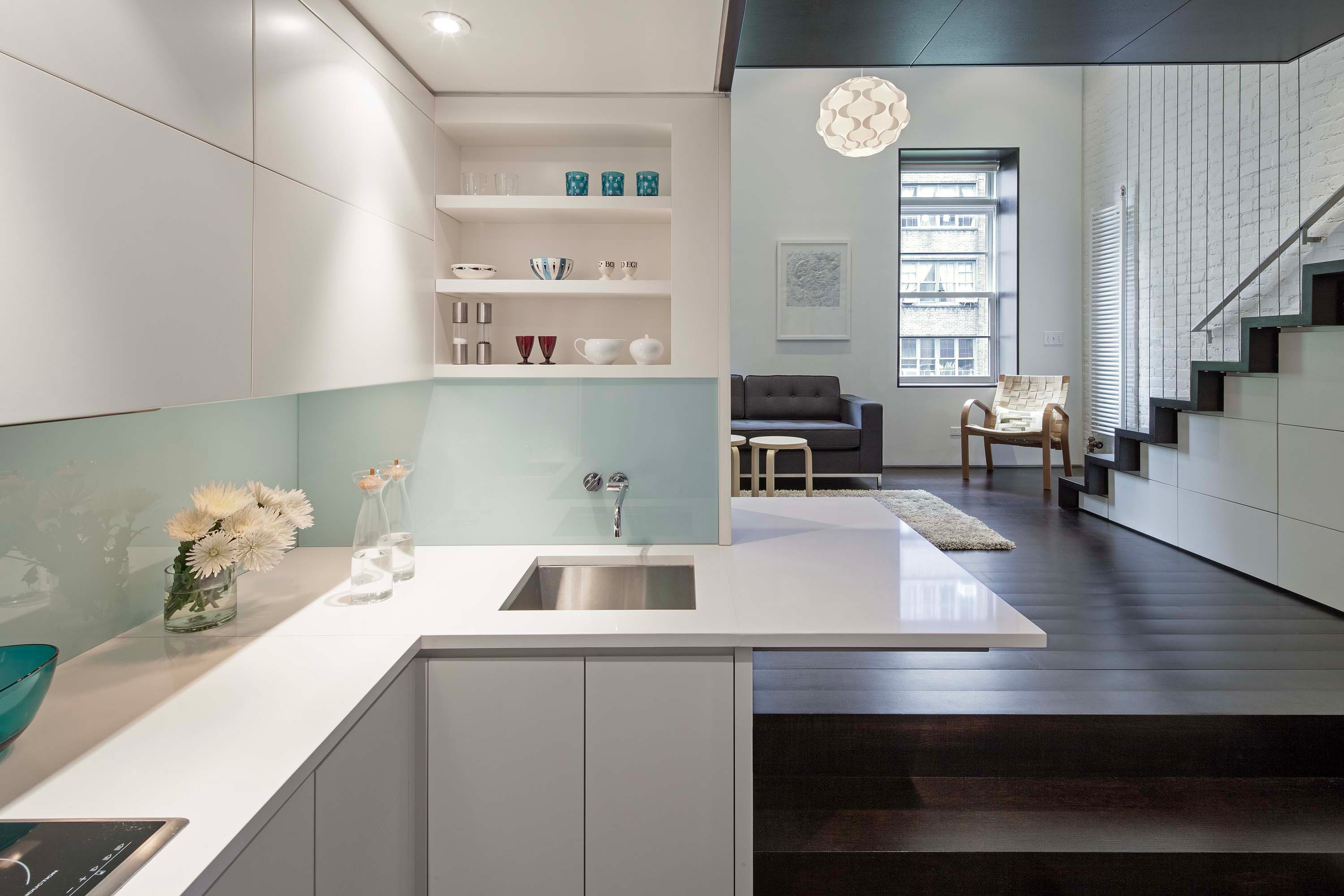 Clean, white kitchen facing living area of Manhattan Microloft by Specht Novak Architects. Shot by Taggart Sorensen.