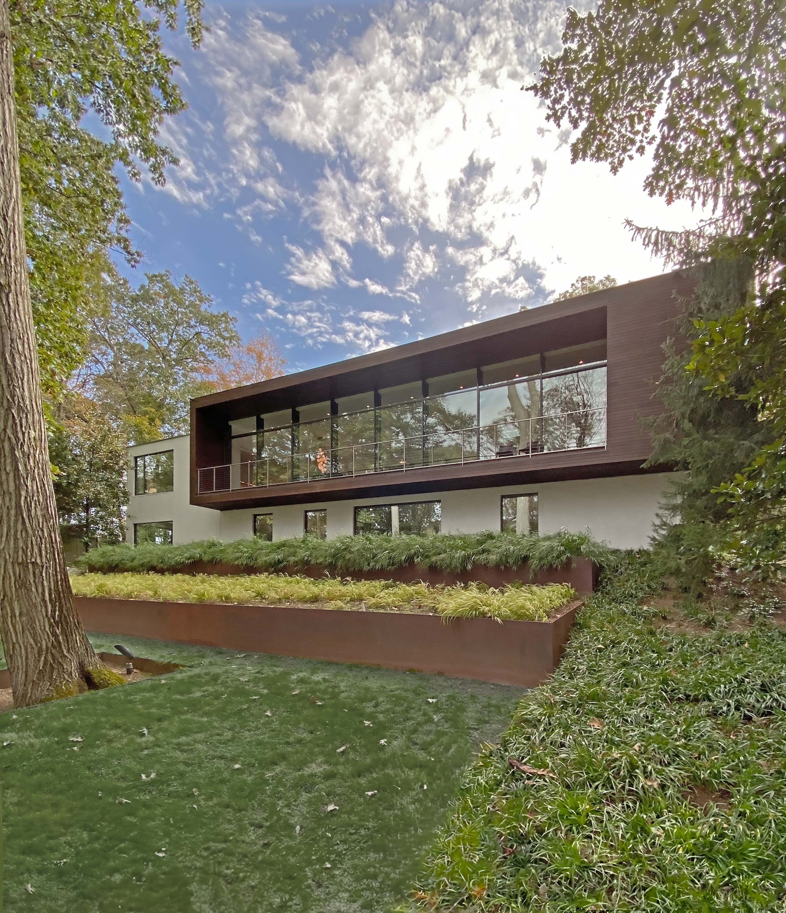Exterior photo of the New Canaan Residence by Specht Novak Architects. Shot by Elizabeth Felicella featuring the side of profile of the home, highlighting the large balcony.