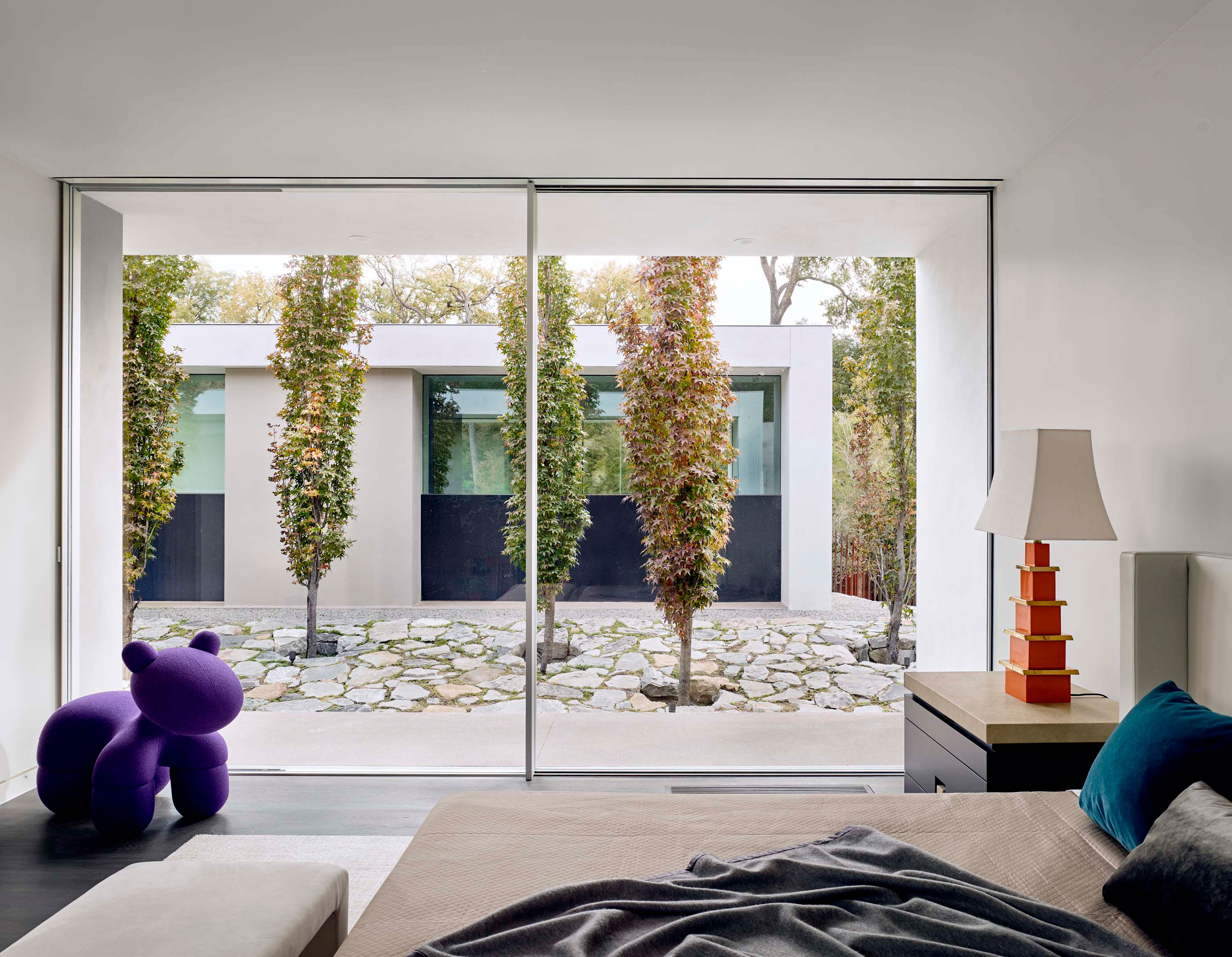 Interior photo of the Preston Hollow Residence by Specht Novak Architects. Shot by Manolo Langis, featuring a floor to ceiling glass wall with views of tree garden.