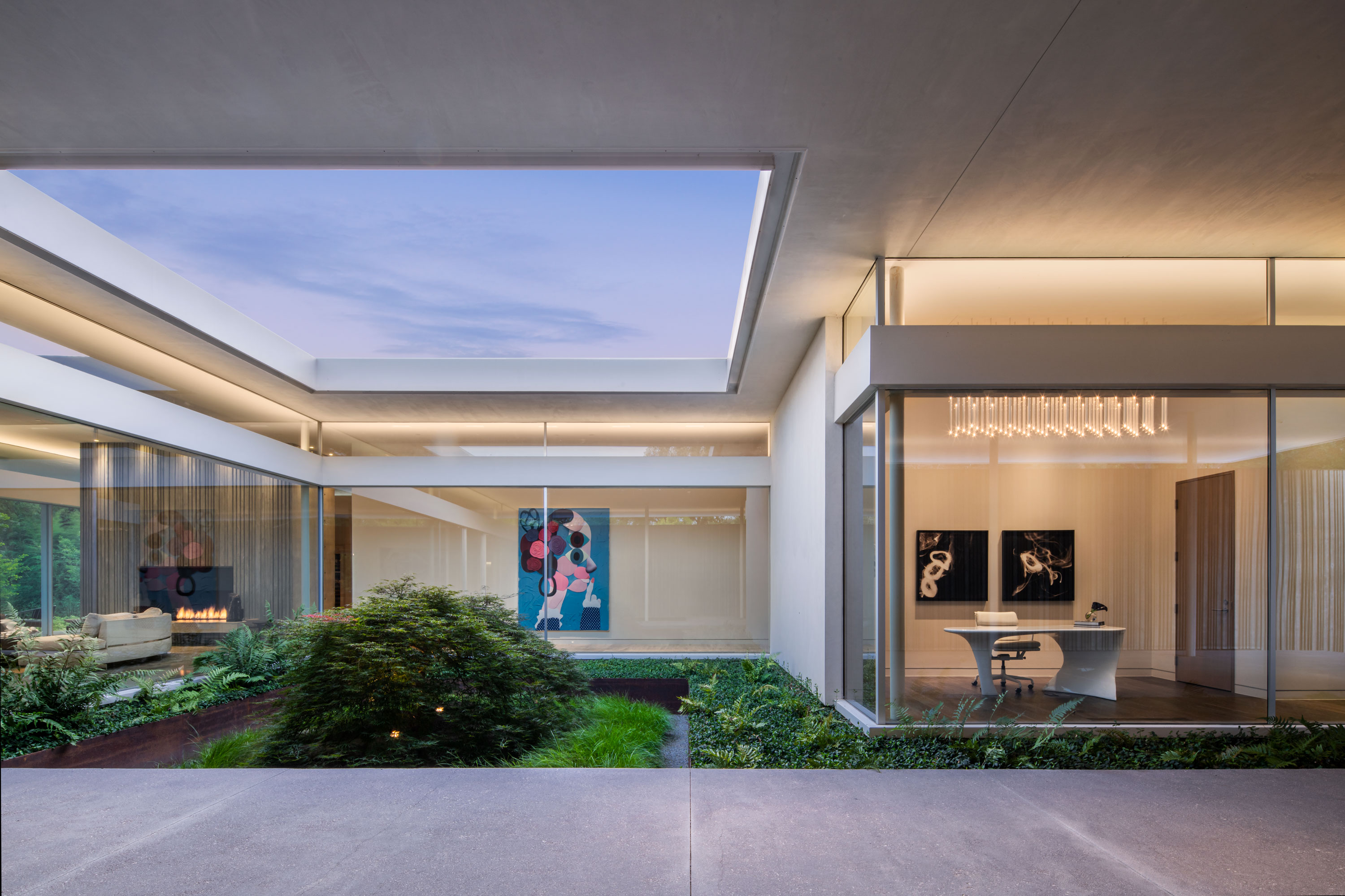 Interior photo of the Preston Hollow Residence by Specht Novak Architects. Shot in the afternoon by Manolo Langis, featuringo a living space, hallway, and office space with views of an indoor garden with open ceiling.
