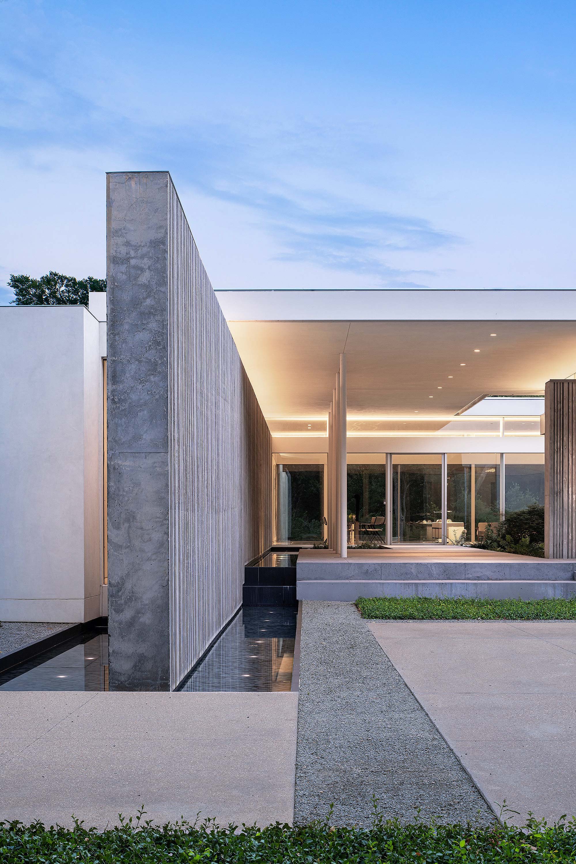 Exterior photo of the Preston Hollow Residence by Specht Novak Architects. Shot by Manolo Langis, featuring the entry to the home, and monolithic concrete wall.