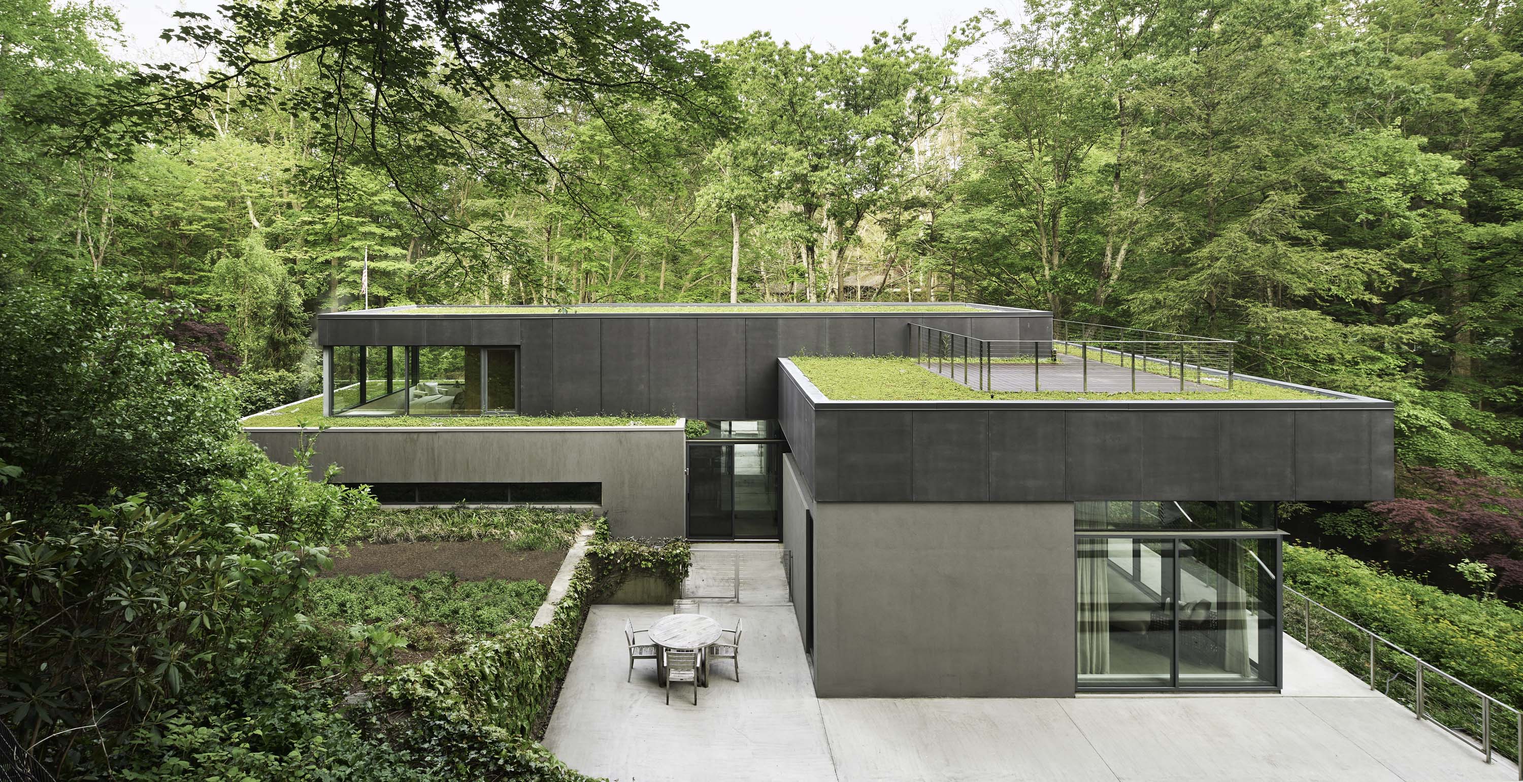 Exterior photo of Weston Residence by Specht Novak Architects. Shot by Jasper Lazor, featuring the concrete and glass home with roof gardens immersed in the landscape.