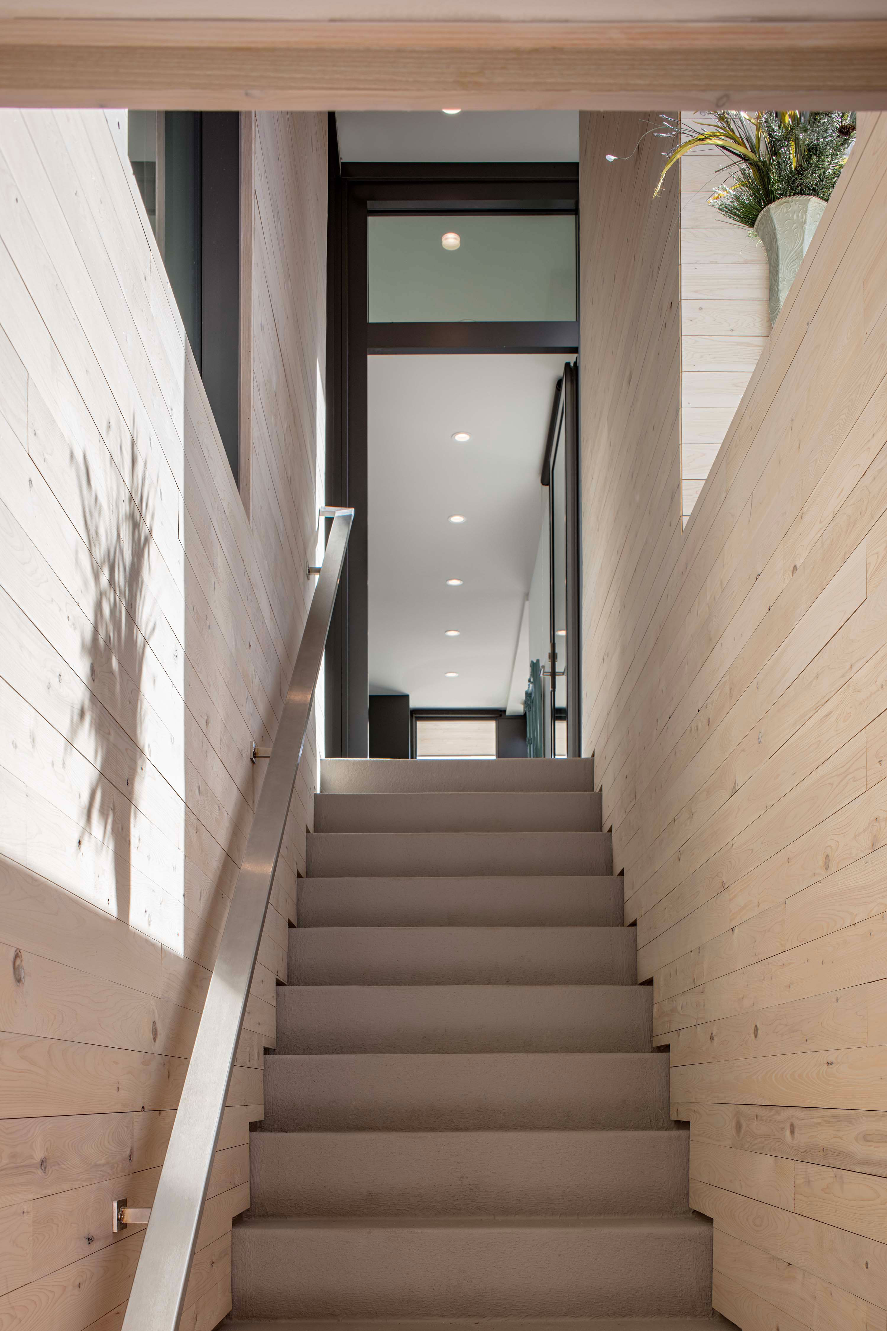 Exterior photo of the Beach Haven Residence by Specht Novak Architects. Shot by Taggart Sorenson featuring stairs framed by the structure of the home.