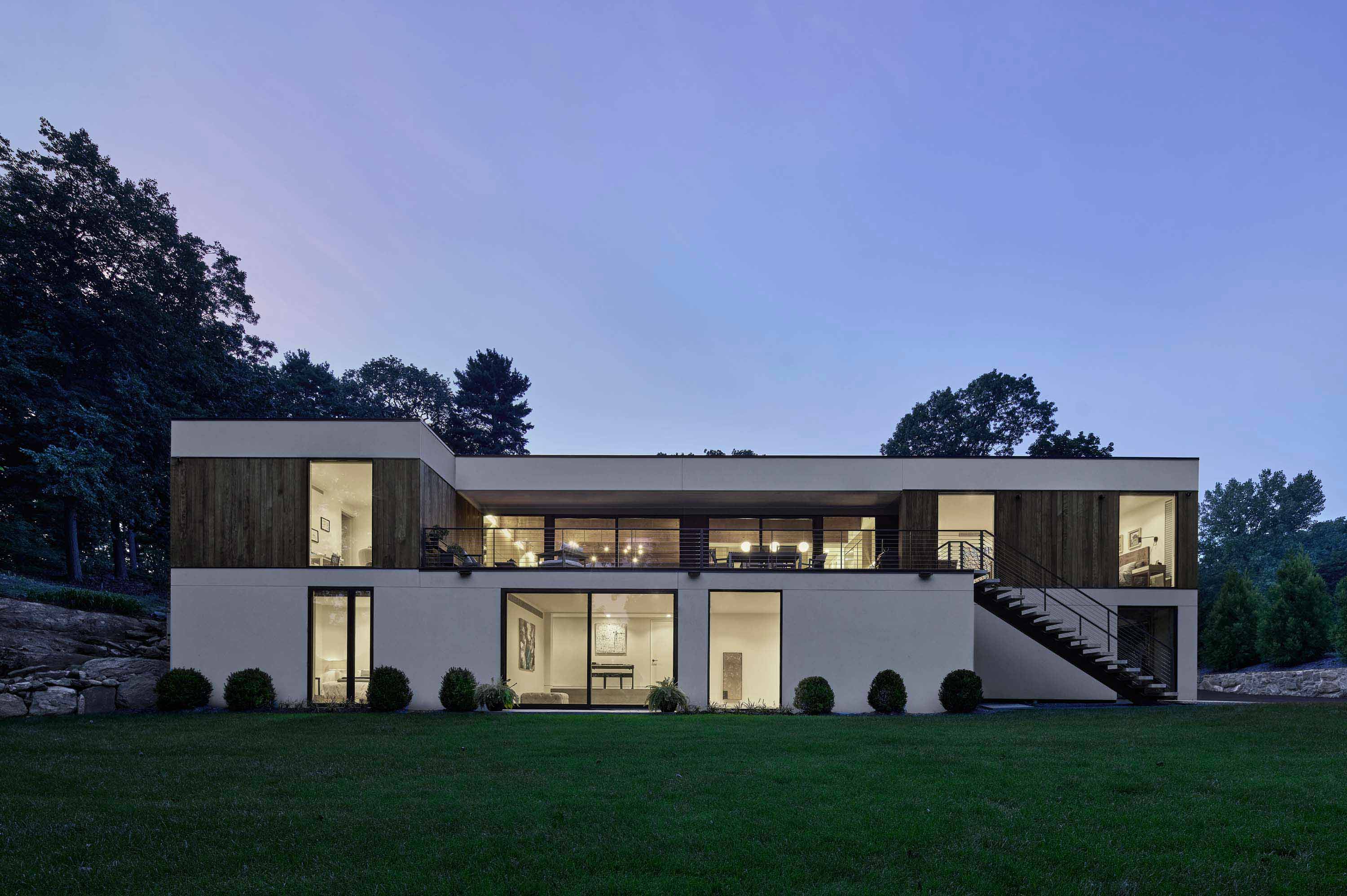 Exterior shot at dusk of Pelham Manor by Specht Novak Architects, showcasing the warmth of the indoors. Shot by Dror Baldinger.