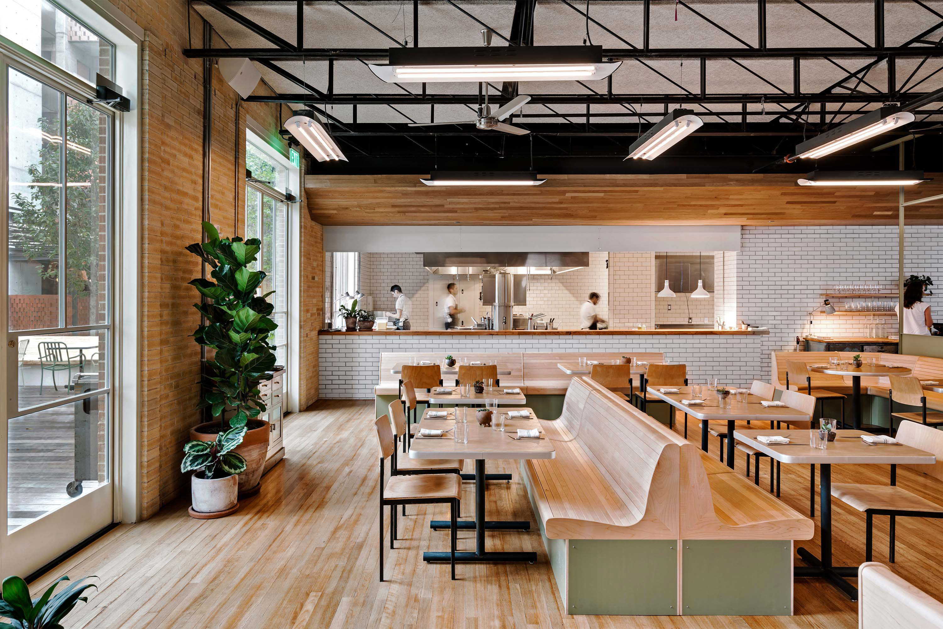 Interior photo of the Carpenter Hotel by Specht Novak Architects. Shot by Chase Daniel, featuring a cozy restaurant with wooden floors, beamed ceilings and large bright windows.