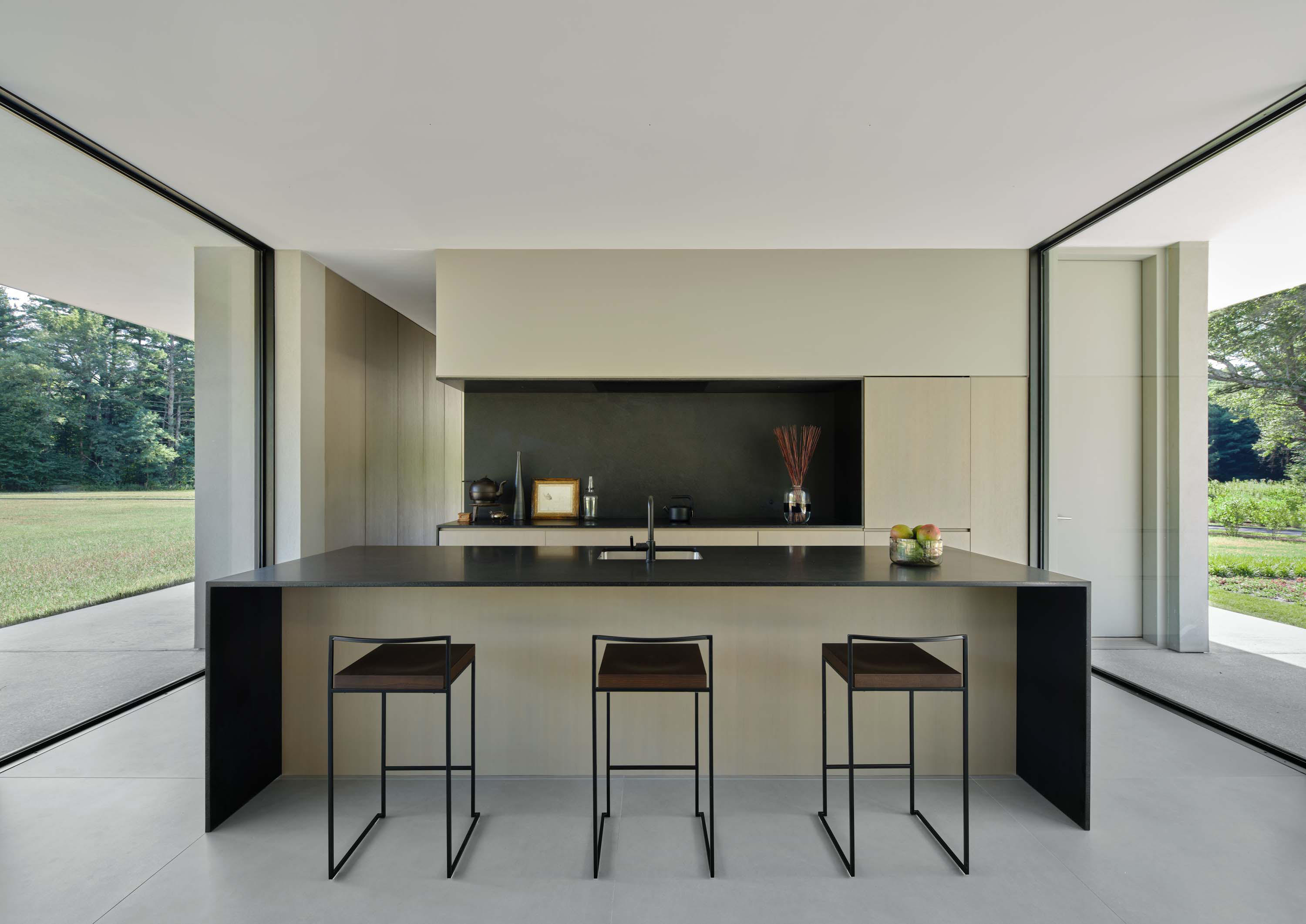 Interior photo of the Casa Annunziata Residence by Specht Novak Architects. Shot by Dror Baldinger, featuring the island kitchen, glass walls, and open space.