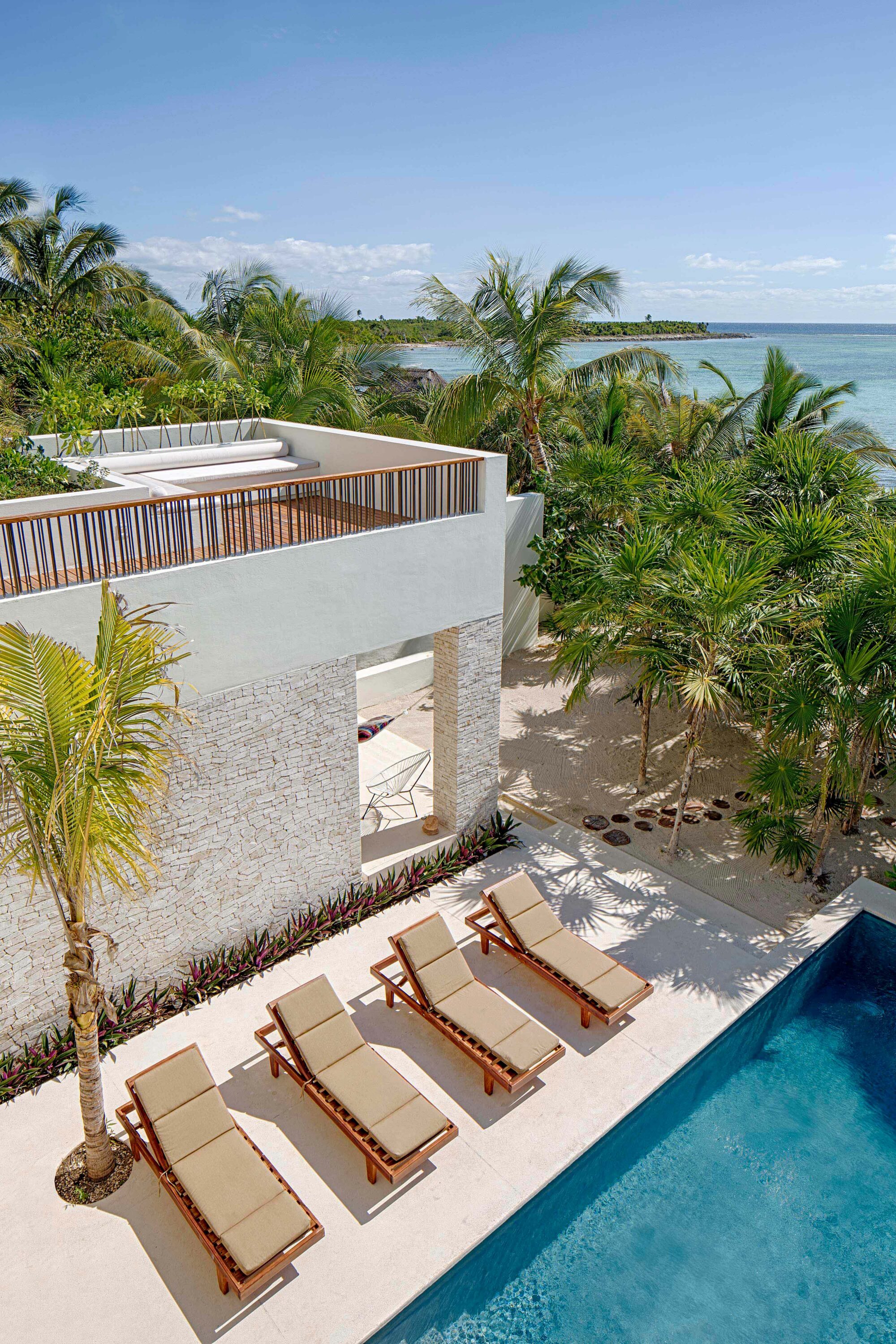 Exterior photo of Casa Xixim by Specht Novak Architects. Shot by Taggart Sorensen, featuring the pool, lounging area, and silhouette of the home from above, with view of the ocean.