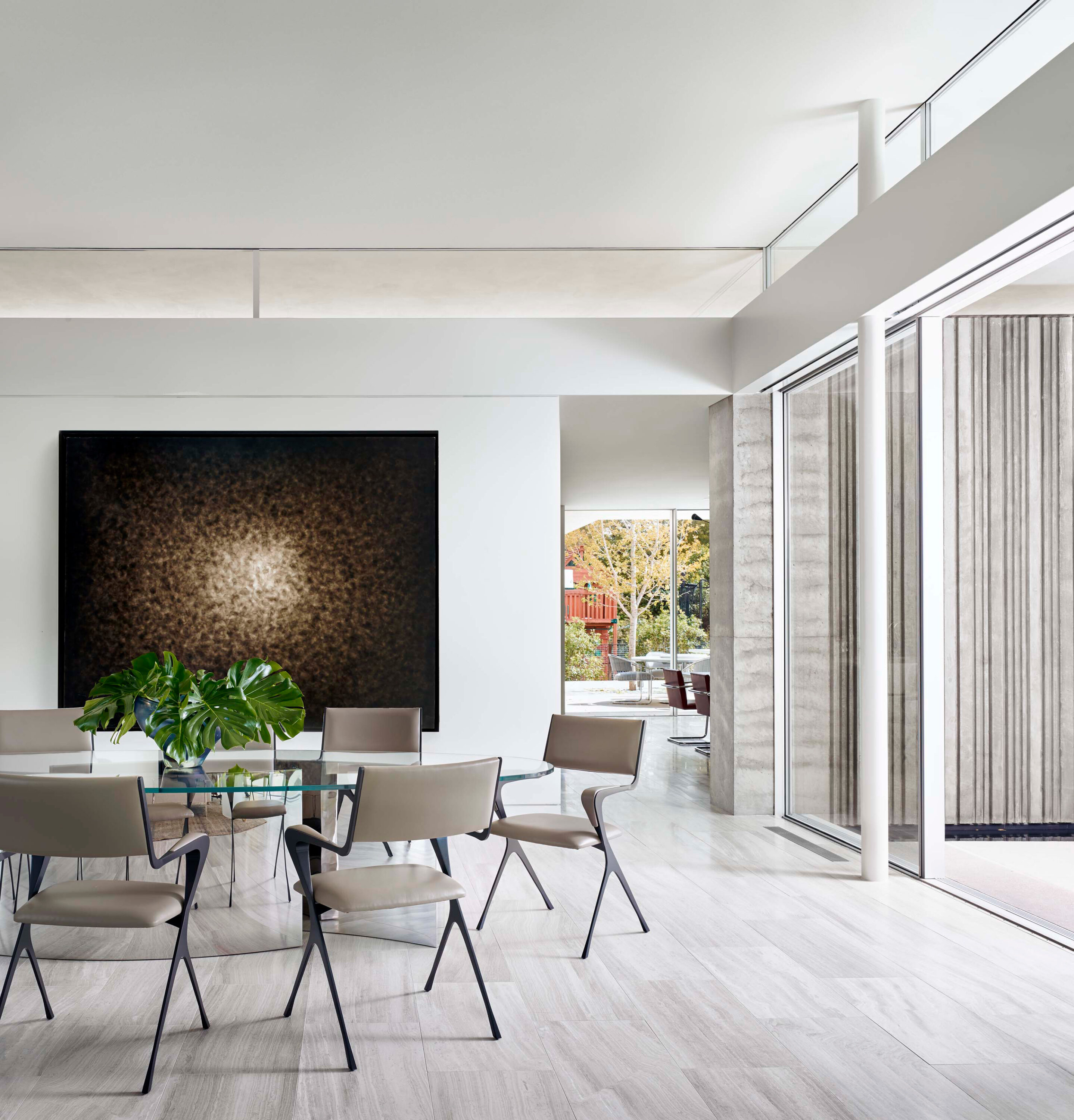 Interior photo of the Preston Hollow Residence by Specht Novak Architects. Shot by Manolo Langis, featuring a dinning area with sliding floor to ceiling glass doors and a hallway towards living area.