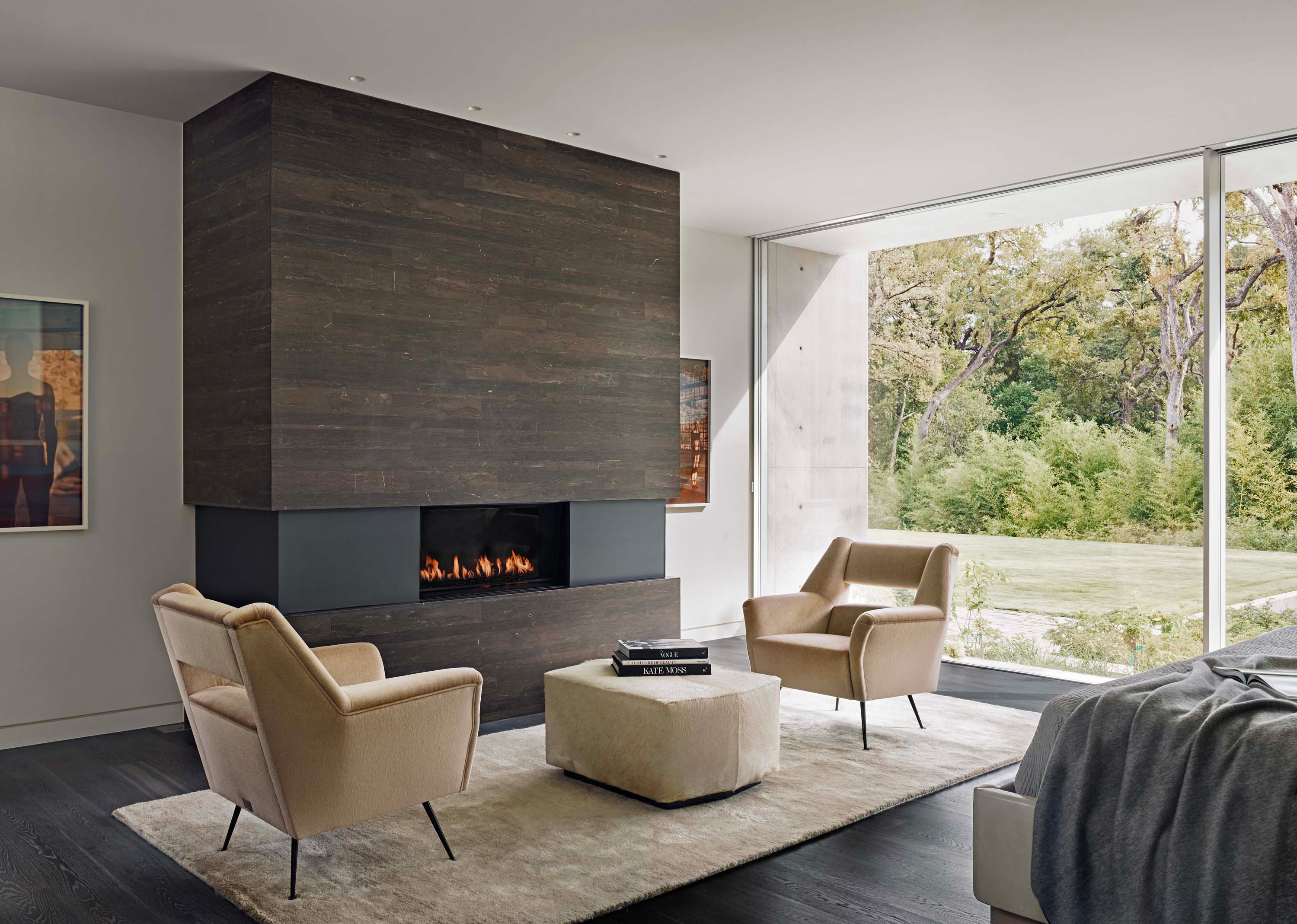 Interior photo of the Preston Hollow Residence by Specht Novak Architects. Shot by Manolo Langis, featuring cozy living area with a fireplace, and views of the backyard.