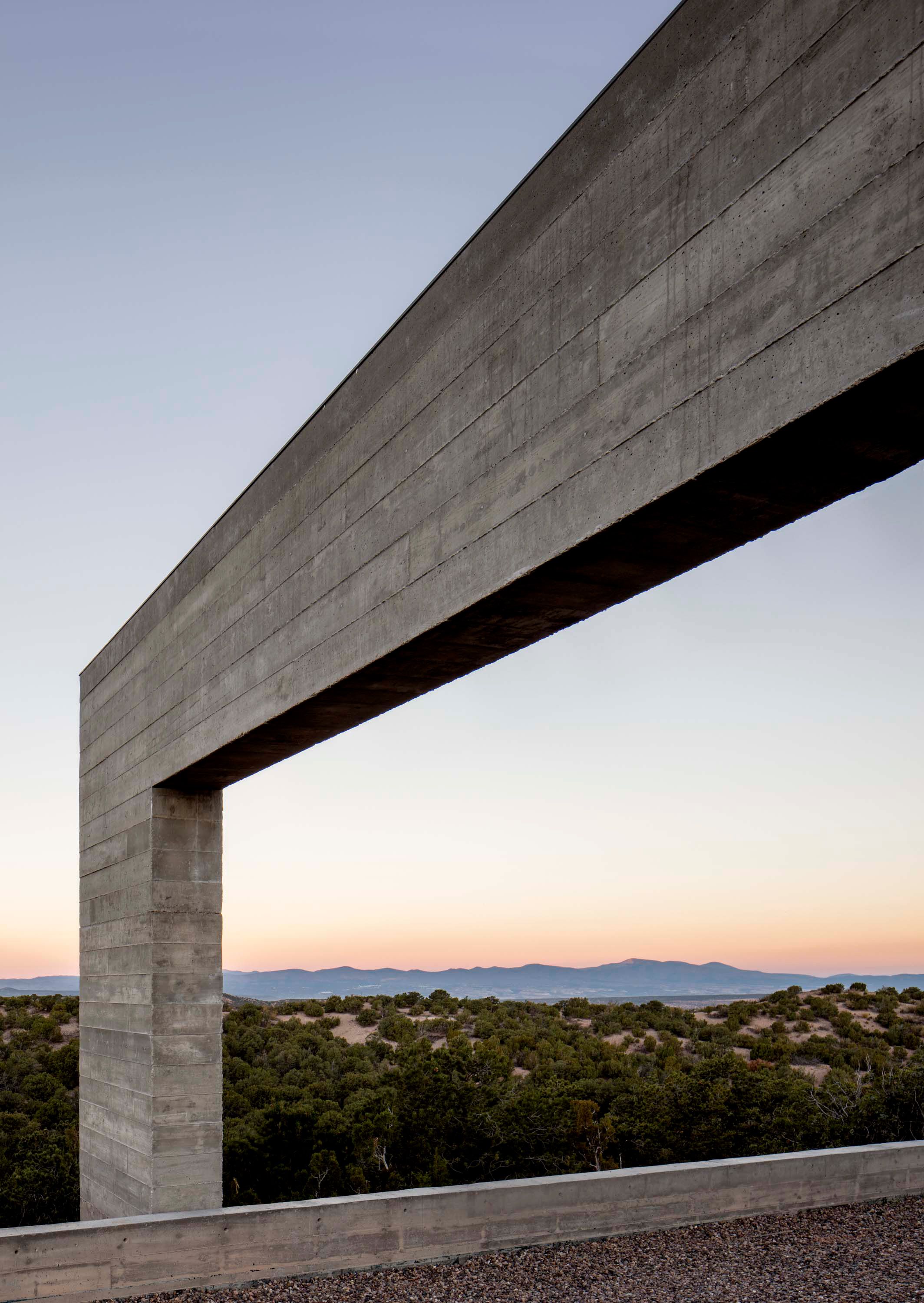 Exterior photo of the Sangre de Cristo House by Specht Novak Architects. Shot by Casey Dunn, featuring how the concrete structure of the home frames its beautiful natural surroundings.