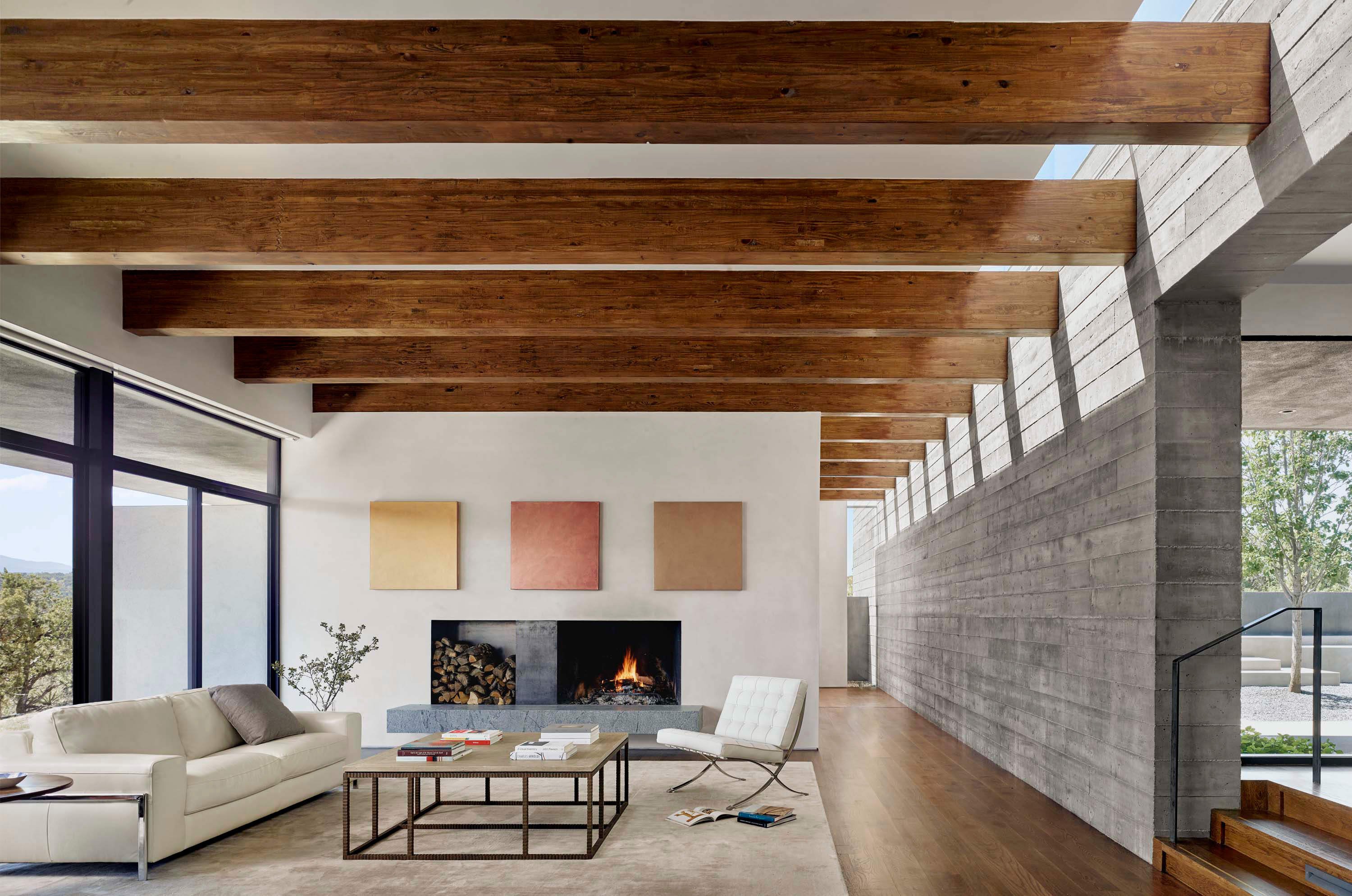 Interior photo of the Sangre de Cristo House by Specht Novak Architects. Shot by Casey Dunn, featuring a bright living area with beamed ceilings, Fireplace, and stairs from entrance area.