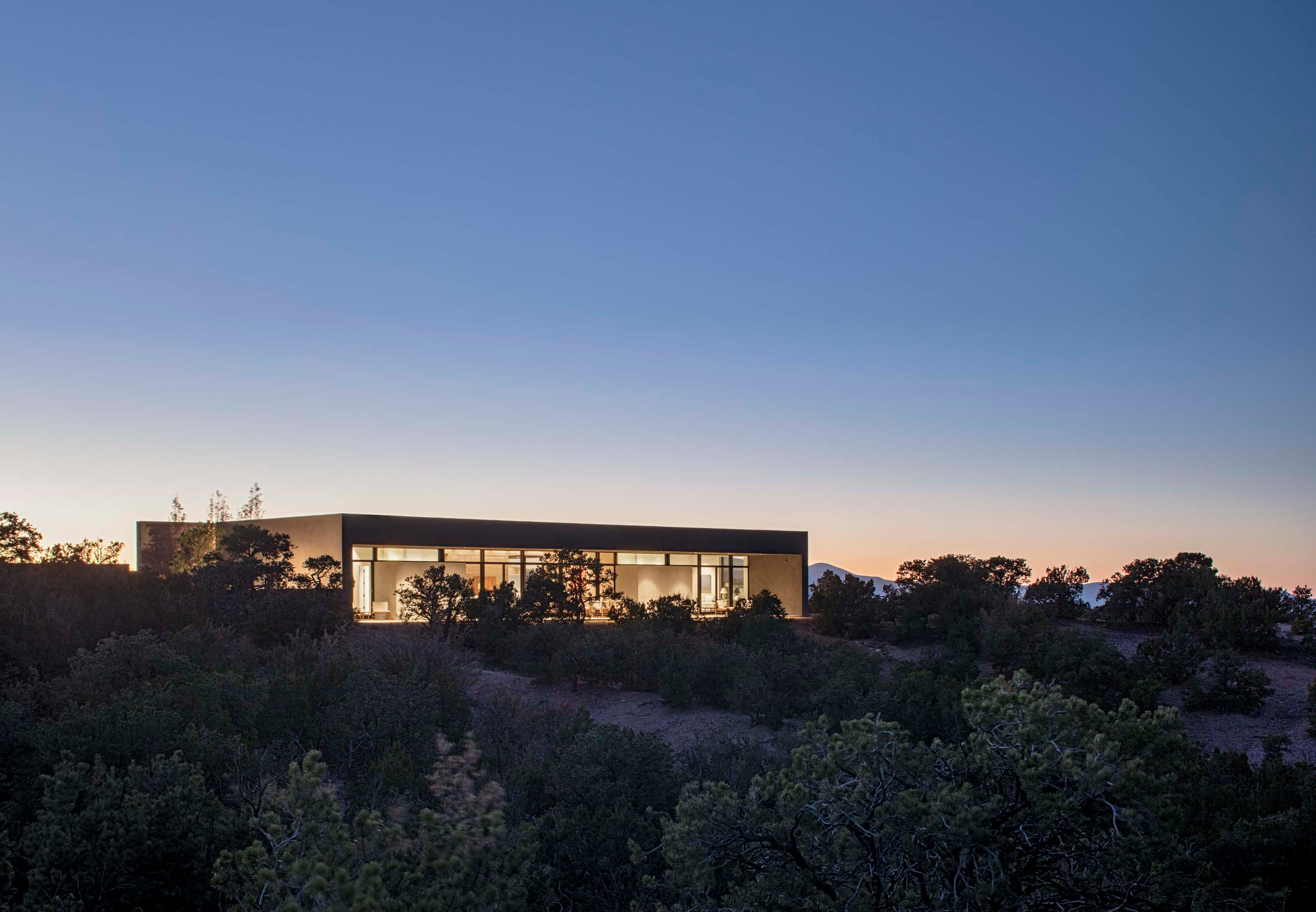 Exterior photo of the Sangre de Cristo House by Specht Novak Architects. Shot at dusk by Casey Dunn, featuring the home from the back garden.