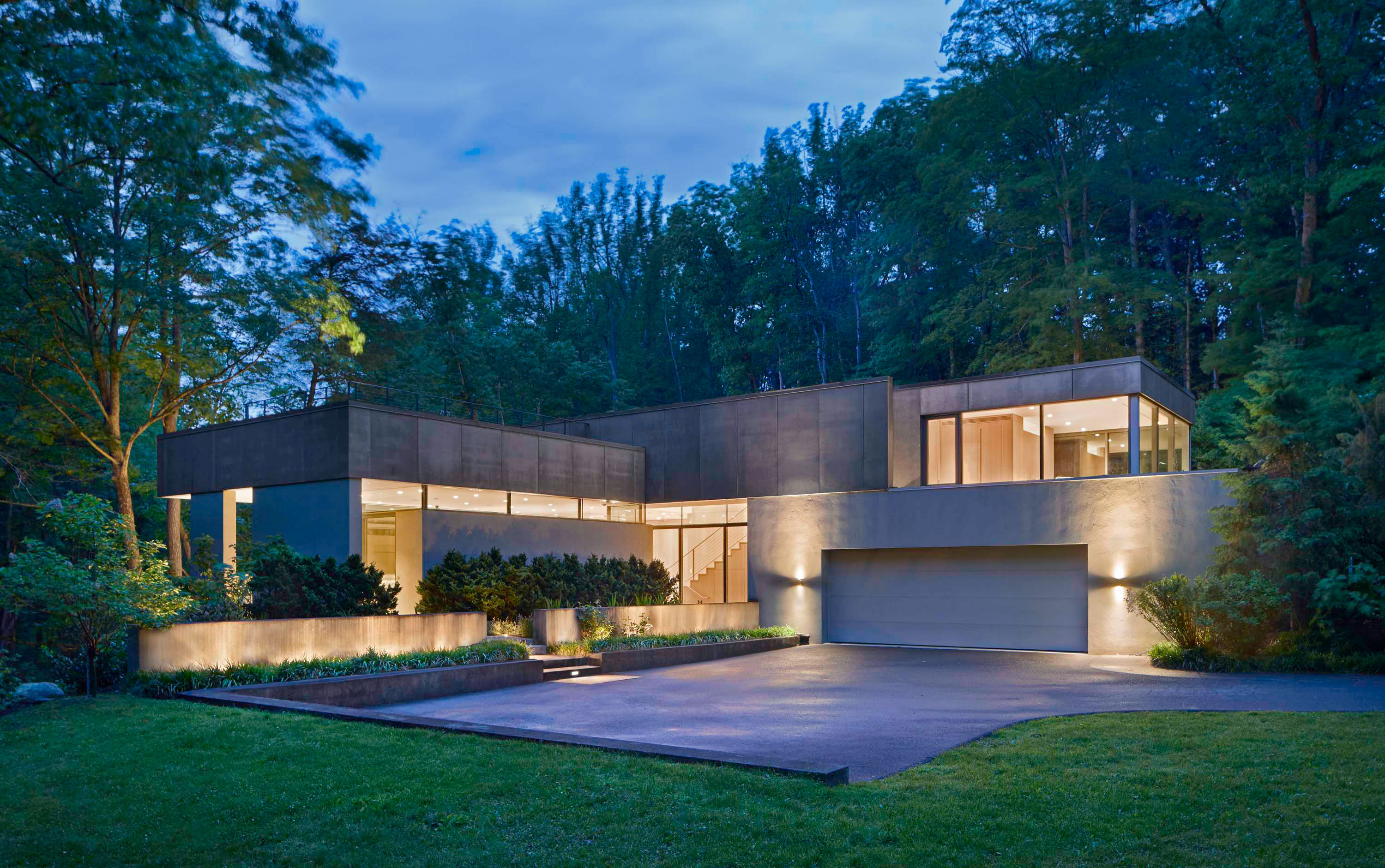 Exterior photo of Weston Residence by Specht Novak Architects. Shot by Jasper Lazor, featuring the facade of the concrete and glass home with roof gardens immersed in the landscape.
