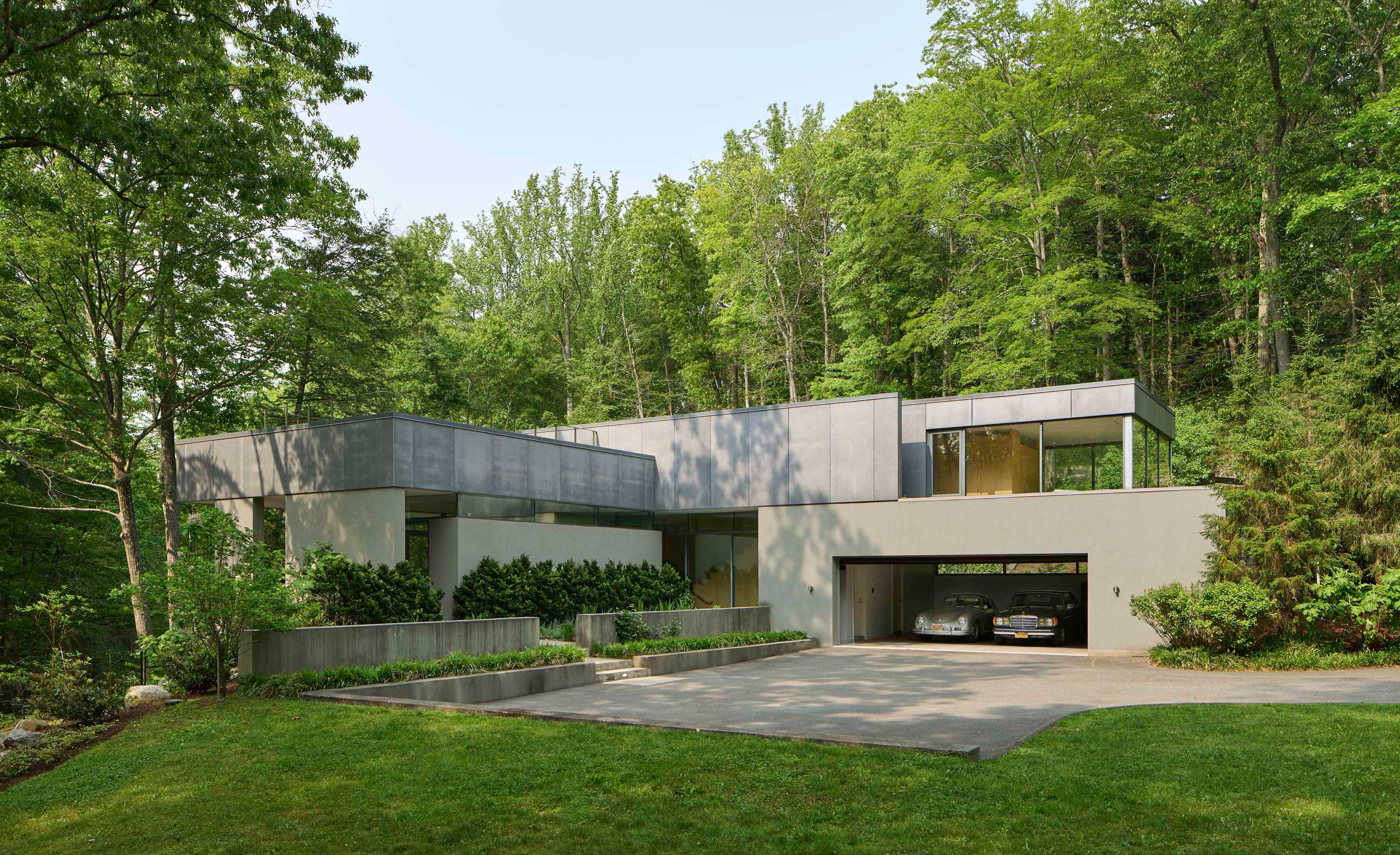 Exterior photo of Weston Residence by Specht Novak Architects. Shot by Jasper Lazor, featuring the concrete and glass home and its parking space.