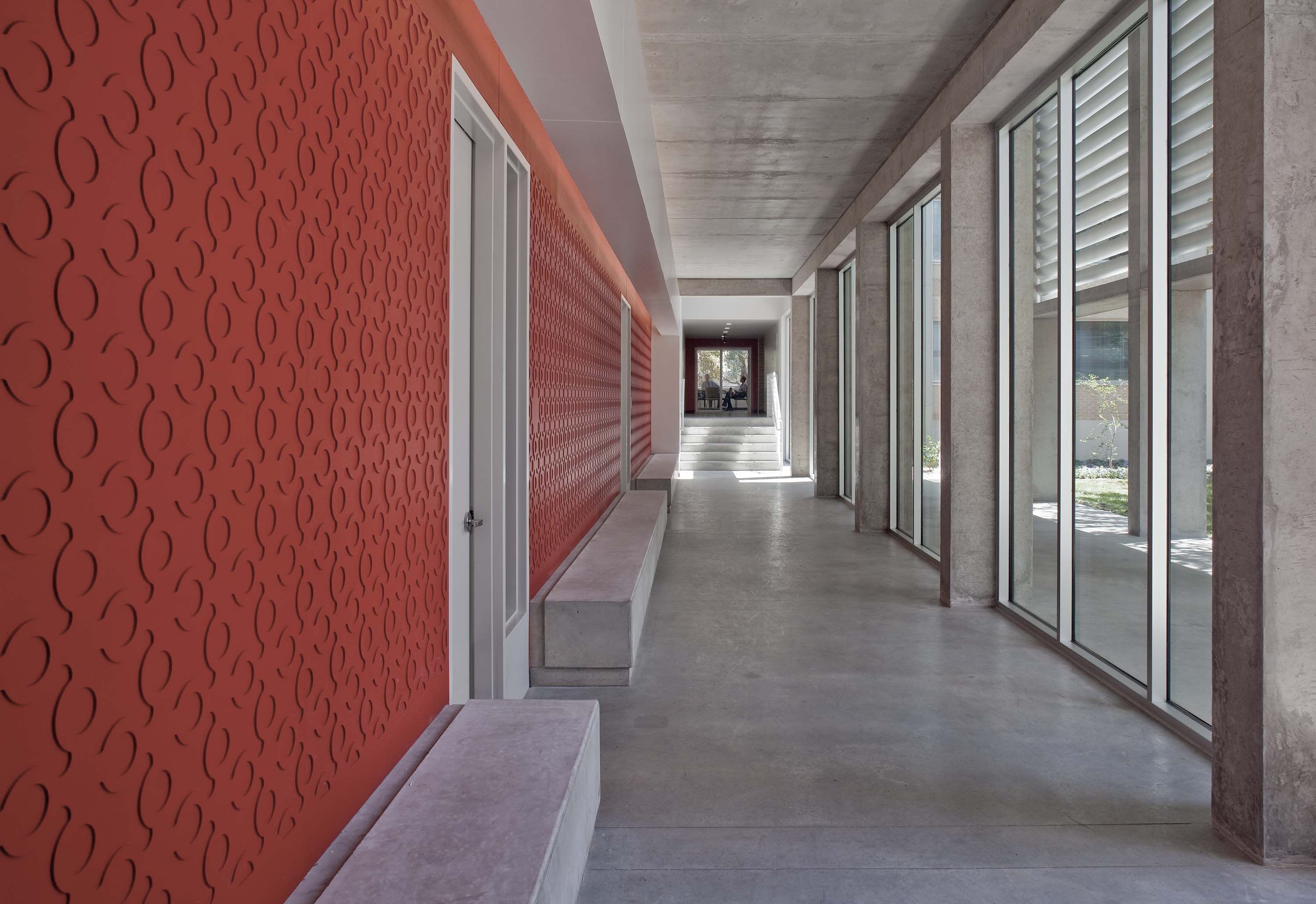Interior hallway featuring large windows to bring natural sunlight working with the colored wall to bring brightness to Doyle Hall by Specht Novak Architects. Shot by Taggart Sorensen.